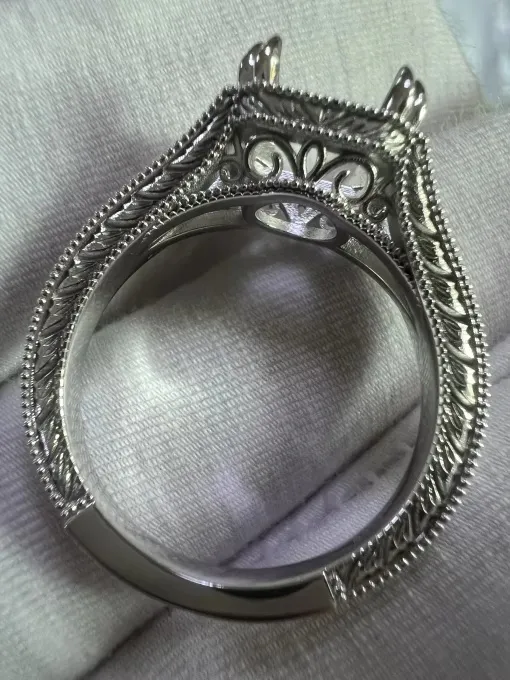 Close-up of an intricate sterling silver ring setting with milgrain detail